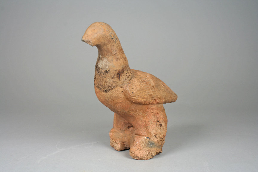A small terracotta figure of a bird.